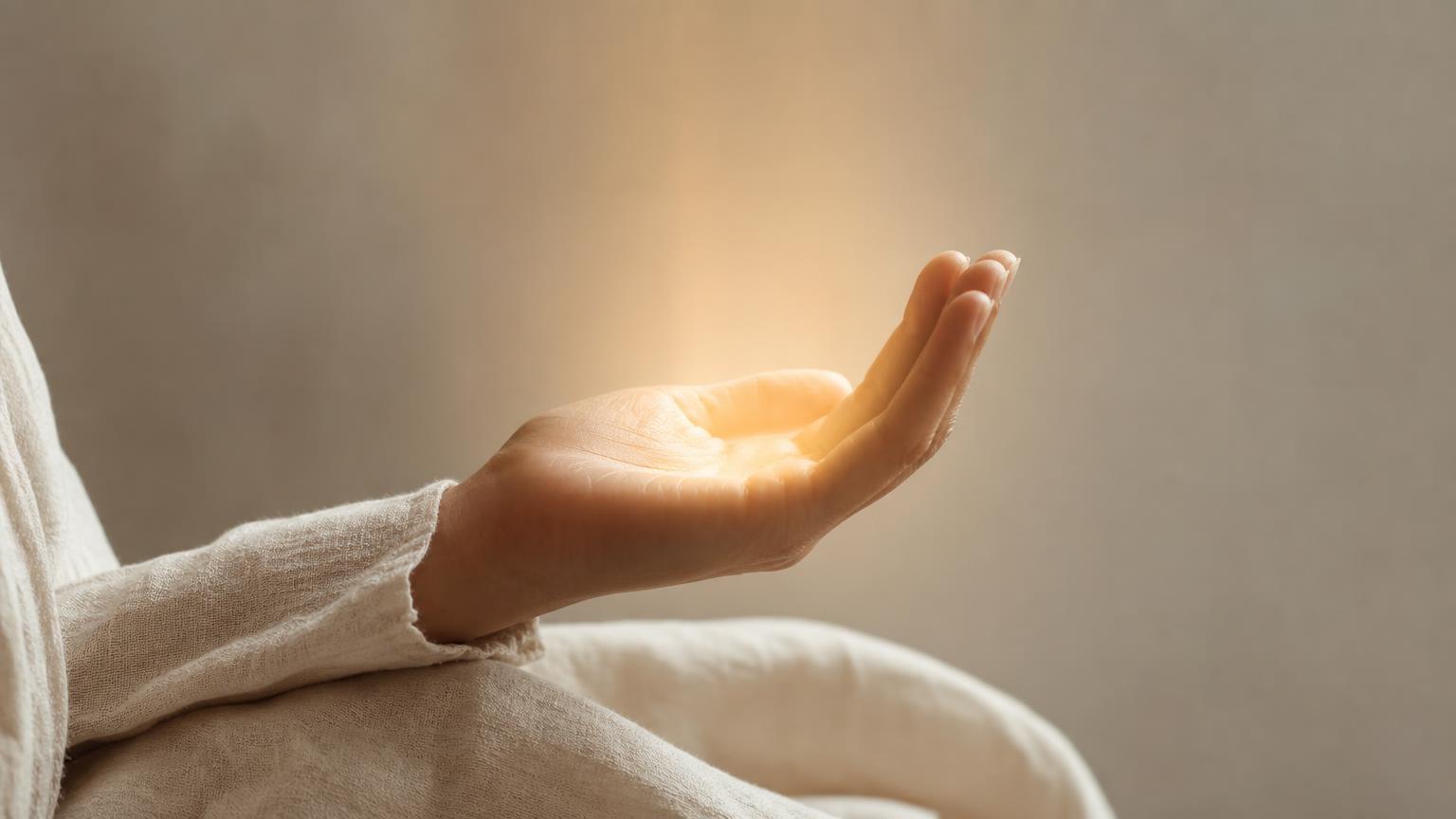 A hand gently holding a soft glow of light, with no visible device — the feeling of technology that has disappeared.